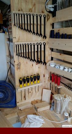 a workbench filled with lots of tools on wooden pallets and hanging from the wall