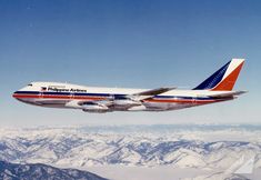 an airplane is flying over the mountains in the day time sky with clouds and snow