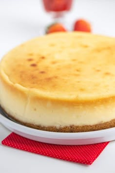 a cheesecake sitting on top of a white plate next to a red place mat