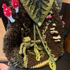 there is a crocheted bag that looks like it has mushrooms and other things on it