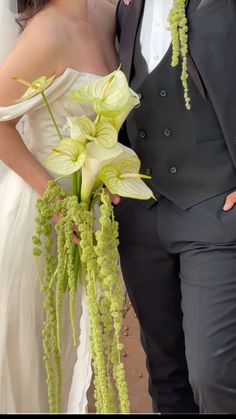 a bride and groom are posing for a wedding photo with flowers in their bouquets