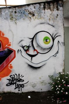 graffiti on the side of a building with an evil face and eyeball painted on it