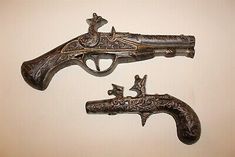 two antique flinters with deer heads on them