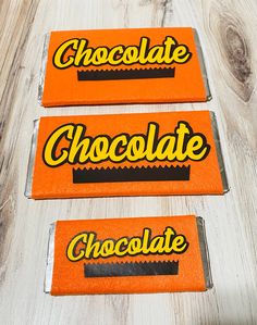 three pieces of chocolate sitting on top of a wooden table next to an orange box