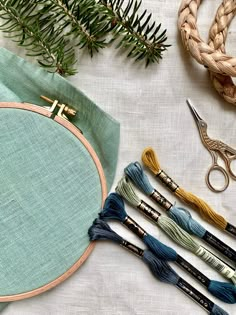 the embroidery kit is next to some scissors and other crafting supplies on a table