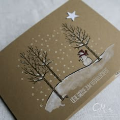 a card with a snowman and trees on it