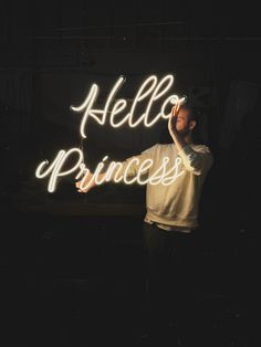 a man standing in front of a neon sign with the words hello princess written on it