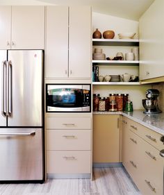 a kitchen with white cabinets and stainless steel appliances, including a refrigerator freezer in the center