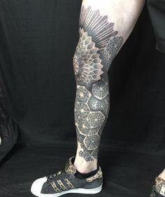 a man's leg with tattoos on it