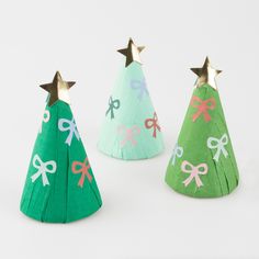 three paper christmas trees with bows on them