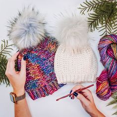 two hats, yarn and knitting needles on a table