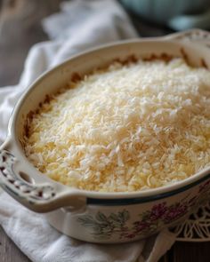 a casserole dish filled with cheese on top of a doily cloth and napkin