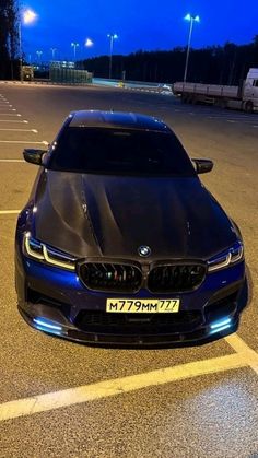 a blue car parked in a parking lot at night