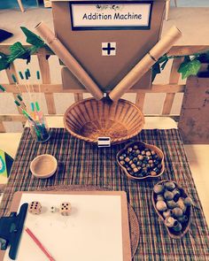 a wooden table topped with bowls filled with dices next to a sign that says addition machine