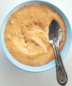 a spoon in a bowl filled with peanut butter