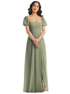 a woman in a long green dress standing with her hands on her hips and looking off to the side