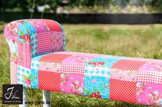 a patchwork bench sitting in the grass