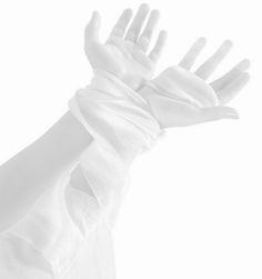 a person's hand with white gloves on it