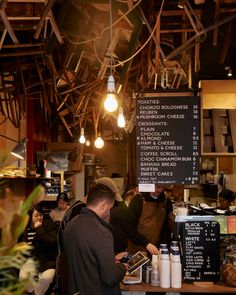 people sitting at tables in a restaurant with menus hanging from the ceiling