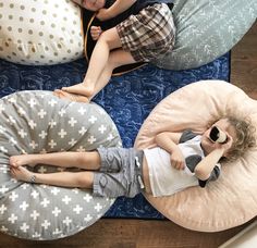 two children are sleeping on bean bags in the living room, while one child is holding a pacifier