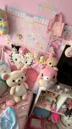 there are many stuffed animals sitting on the bed in this child's room with pink walls