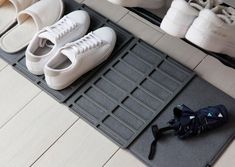 several pairs of white shoes sitting on top of a mat