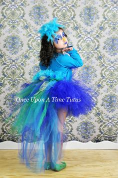 The Jungle Bird Feather Tutu  This stunning blue bustle tutu is perfect for birthday parties, gifts, Halloween costumes, and dress up! It features a sold royal blue tutu in the front, and the bustle represents the gorgeous tail with colors of blue, green, and yellow and is sure to give your tutu an added pop! Added to the back of the bustle is gorgeous turquoise feathers. The feathers are on removable clips to allow this to be worn with and without the feathers. Stunning!  Sizes and Lengths:... Blue Bird Costume, Feather Bustle, Peacock Tutu, Seussical Costumes, Long Tutu Skirt, Feather Tutu, Parrot Costume, Jungle Bird, Girls Tulle Skirt