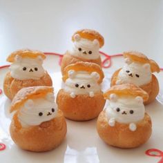 small pastries with white frosting and teddy bears on them sitting on a plate