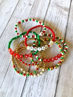 three bracelets with beads and merry written on them sitting on a wooden floor next to each other