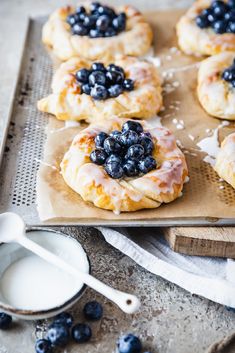 blueberry danish pastries are sitting on a cutting board