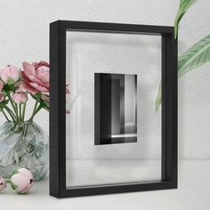 a vase filled with pink flowers sitting next to a wall