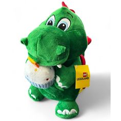 a green stuffed animal with a tag on it's chest