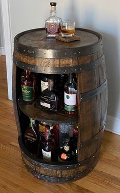 a wooden barrel table with liquor bottles on it