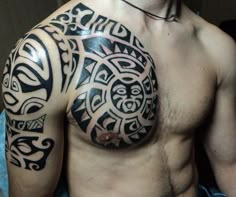 a man's chest with an intricate tattoo design on his arm and chest area