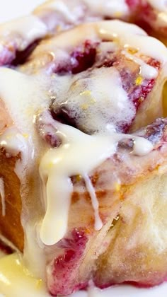 a close up of a pastry on a plate with icing and fruit toppings