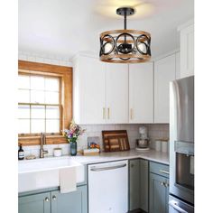 a kitchen with green cabinets and white walls, including a light fixture over the sink