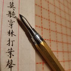 a fountain pen sitting on top of a piece of paper with writing in chinese characters