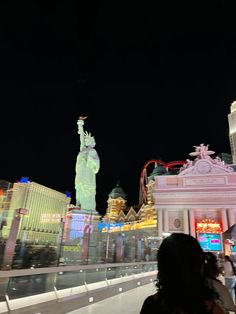 the statue of liberty is lit up at night in front of las vegas's famous hotel and casino