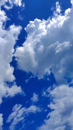 an airplane is flying through the blue sky with white clouds in the backgroud