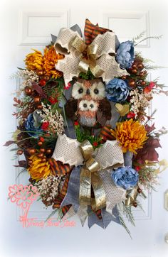 a wreath with an owl and flowers on it