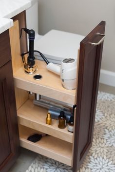 an open cabinet in the corner of a bathroom