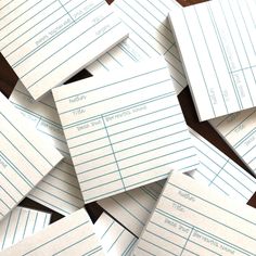 several pieces of lined paper sitting on top of a wooden table next to each other