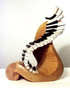 a wooden sculpture with black and white strips on it's body, in the shape of a bird