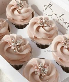 cupcakes with pink frosting and pearls in a box