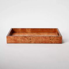 a wooden tray with holes in the middle on a white background, it is empty