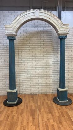 two blue and white pillars sitting on top of a hard wood floor next to a brick wall