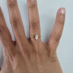 a person's hand with a ring on it and a diamond in the middle