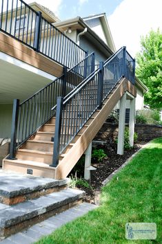 a house with stairs leading up to the front door and side yard area on either side