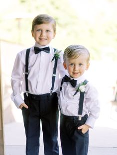 two young boys dressed in formal wear standing next to each other