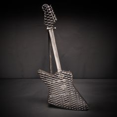 a metal guitar shaped sculpture sitting on top of a table